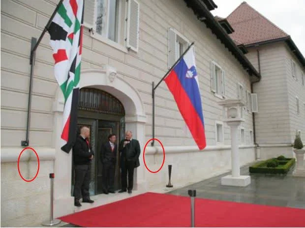 Madeži na fasadi pod nosilcem za zastavo